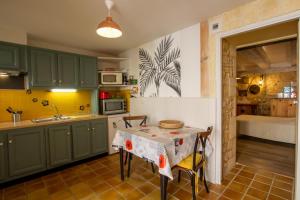 a kitchen with green cabinets and a table at Le gentil coquelicot in Saint-Pompont +8 photos
