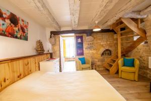 a bedroom with a bed and two chairs in a room at Le gentil coquelicot in Saint-Pompont