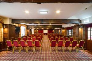 an empty room with red chairs and a stage at The Atherstone Red Lion Hotel in Atherstone