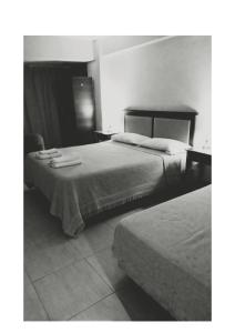 a black and white photo of a bedroom with two beds at Hotel Libanno Apartt in Villa Mercedes