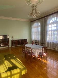 a dining room with a table and chairs and a chandelier at Heritage Garden Villa by Eldar in Ganja