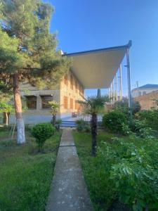 a building with a walkway in a yard with trees at Heritage Garden Villa by Eldar in Ganja