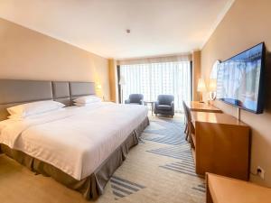 a hotel room with a large bed and a flat screen tv at Beijing XinQiao Hotel in Beijing