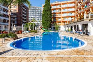 a large blue swimming pool in front of a building at Hotel Bon Repos in Calella