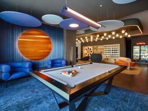 a billiard room with a pool table and blue chairs at ibis Styles Katowice Airport in Pyrzowice