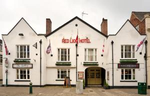 a white building with a red roof hotel at The Atherstone Red Lion Hotel in Atherstone
