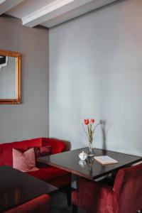 a dining room with a black table and red chairs at Josis Klause Café I Pension in Albstadt