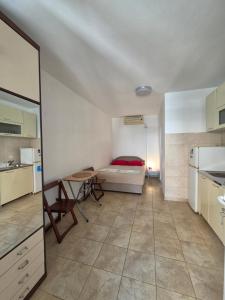 a room with a bed and a table and a kitchen at Apartmani Viki in Sutomore