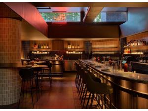 a restaurant with a bar with tables and chairs at Hyde Melbourne Place in Melbourne +98 photos