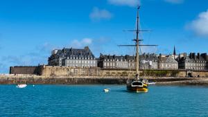 a sail boat in the water in front of a castle at Le Blue Note intra-muros - Bel appartement de standing in Saint Malo