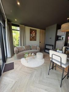 a living room with a couch and a table at Wellnesslodge Specht jacuzzi and sauna and privacy in Dalerveen