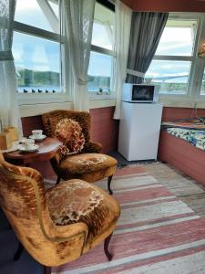 a room with two chairs and a table and a bed at Kystbua 360 in Saltstraumen