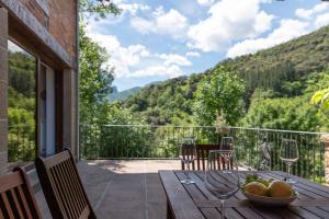 a wooden table with a bowl of fruit on a balcony at Fidalsa Paradise Point in Cabezón de Liébana