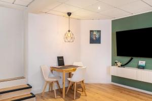 a dining room with a table and chairs and a flat screen tv at Ferien- und Handwerkerwohnung in Römhild