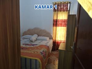 a bedroom with a bed with a dog laying on it at Prima Homestay Tuktuk in Sinapuran