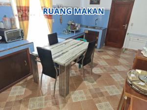 a kitchen with a table and chairs in a room at Prima Homestay Tuktuk in Sinapuran