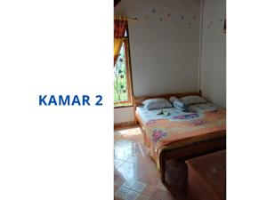 a bedroom with a bed and a window at Prima Homestay Tuktuk in Sinapuran