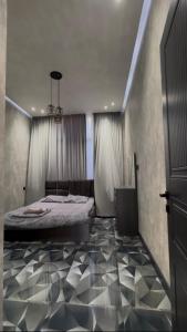 a bedroom with a bed and a black and white floor at Palm Villa in Mərdəkan