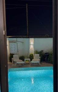 a view of a swimming pool with two chairs and a table at Palm Villa in Mərdəkan +3 photos