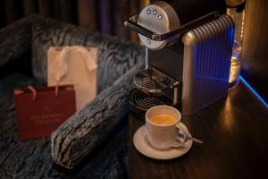 a cup of coffee on a table next to a coffee maker at The Residence Hotel in Galway