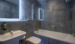 a bathroom with a sink and a tub and a toilet at The Residence Hotel in Galway