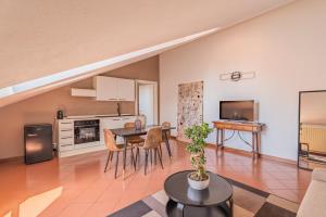 a living room with a table and a kitchen at Piazza Michele Ferrero - sulla piazza centrale in Alba