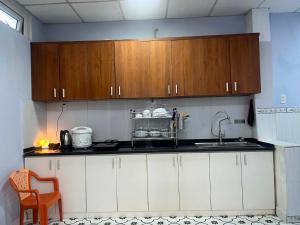 a kitchen with white cabinets and a sink at Bắp Bơ Homestay in Cồn Giả Viên