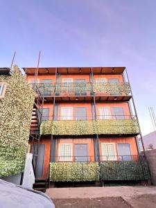 an orange building with plants on the side of it at Hospedaje Oasis Modulares in Calama