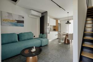 a living room with a blue couch and a kitchen at Agia Triada Suites in Heraklio