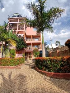 a building with a palm tree in front of it at Amazing Grace Home - Oyugis studio in Oyugis
