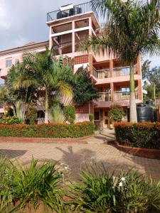 a large building with palm trees in front of it at Amazing Grace Home - Oyugis studio in Oyugis
