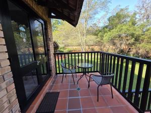 a patio with two chairs and a table on a balcony at Azalea at Greenway Woods in White River