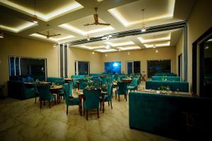 a banquet hall with tables and chairs in a room at Mango Bloom River Resort By Excel Hotels & Resorts in Marchula