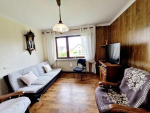 a living room with a couch and a tv at Gite Les Ptits Biscuits in Vittersbourg