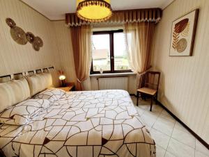 a bedroom with a bed and a chair and a window at Gite Les Ptits Biscuits in Vittersbourg