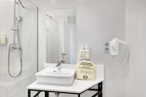 ein weißes Badezimmer mit Waschbecken und Dusche in der Unterkunft B&B HOTEL Granada in Pulianas + 50 Fotos
