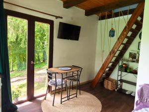 a room with a table and two stools and a staircase at UNDER THE GREEN ROOF in Blaževića Dol