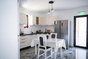 a white kitchen with a table and a refrigerator at Breb 155 in Breb