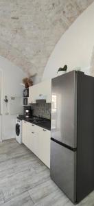 a kitchen with a stainless steel refrigerator and a stove at Casa Italiannebrasille in Castellana Grotte