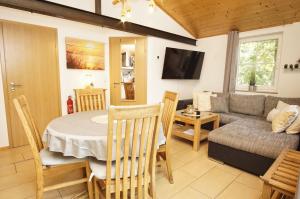 a kitchen and living room with a table and a couch at Chalet Ostsee Nr 72 in Göhren