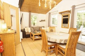 a dining room and living room with a table and chairs at Chalet Ostsee Nr 72 in Göhren