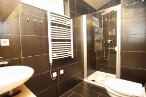 a bathroom with a shower and a toilet and a sink at Chalet Ostsee Nr 72 in Göhren +20 photos
