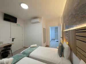 a bedroom with a white bed and a desk at Hotel Boutique Traveler 360 in Madrid