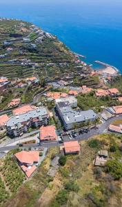 an aerial view of a town with buildings and the ocean at Meu Quintal 3, Calheta-Madeira in Calheta