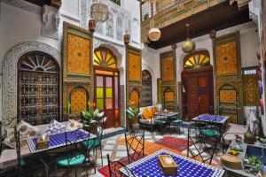 a room with tables and chairs in a building at Riad Zayna Fes in Fez