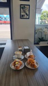 a table with three plates of pastries and a cup of coffee at Residence Meraviglia in Schio +3 photos