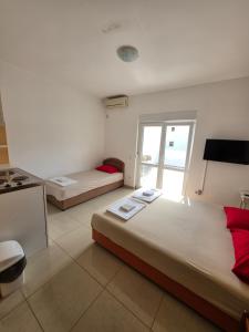a hotel room with two beds and a window at Apartmani Viki in Sutomore