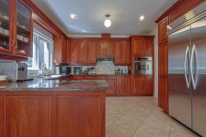 a kitchen with wooden cabinets and a stainless steel refrigerator at Harmony House in Richmond Hill