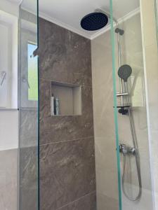 a shower with a glass door in a bathroom at Apartmani Sweet Dreams in Banja Luka