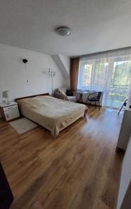 a bedroom with a large bed and a living room at APARTAMENT U MARYSI in Krościenko